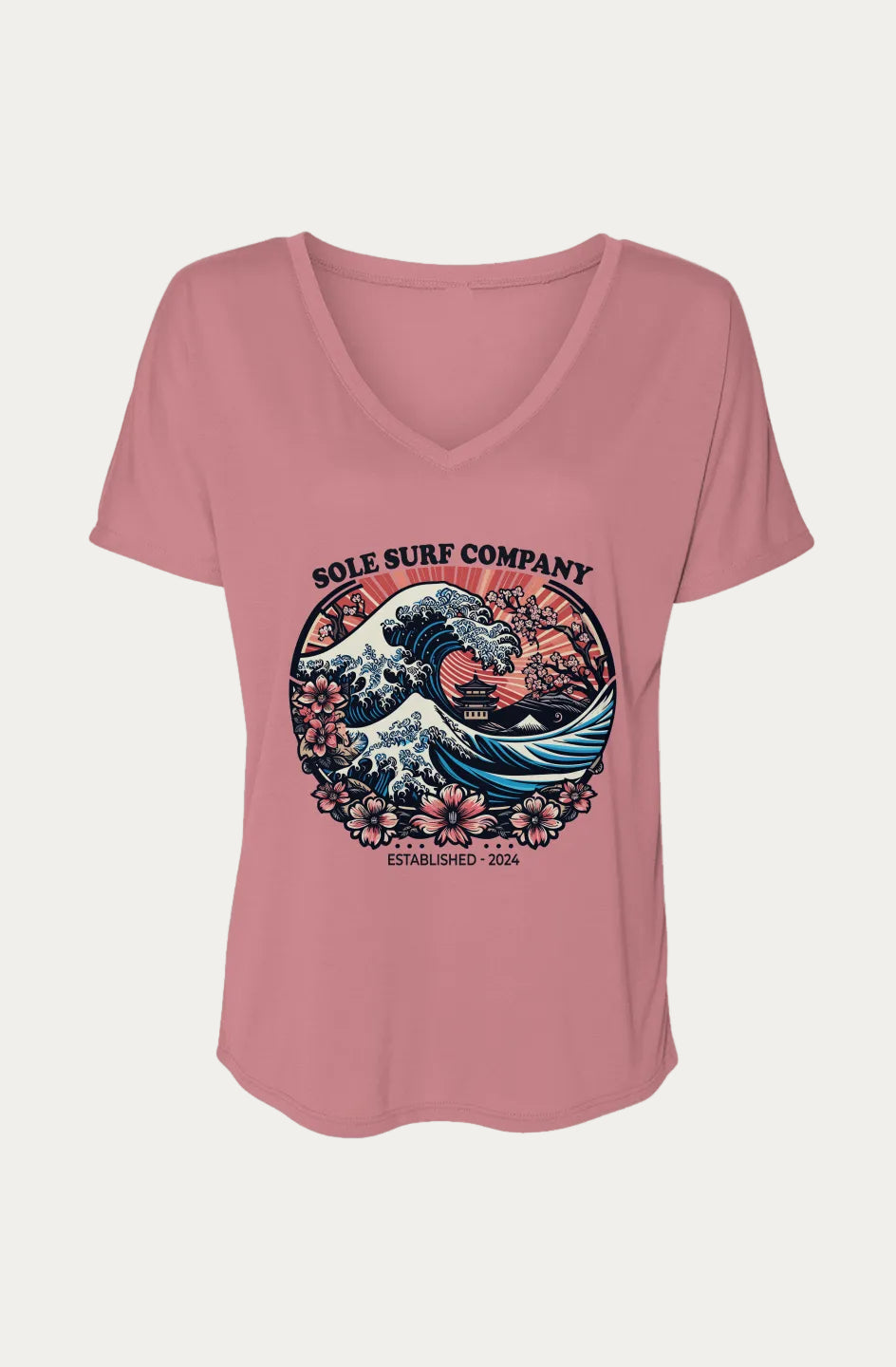 A dusty pink short-sleeve V-neck t-shirt with a circular graphic on the chest featuring a surfer riding a wave, inspired by 'The Great Wave off Kanagawa', with the text 'SOLE SURF COMPANY' and 'EST. 2024'.