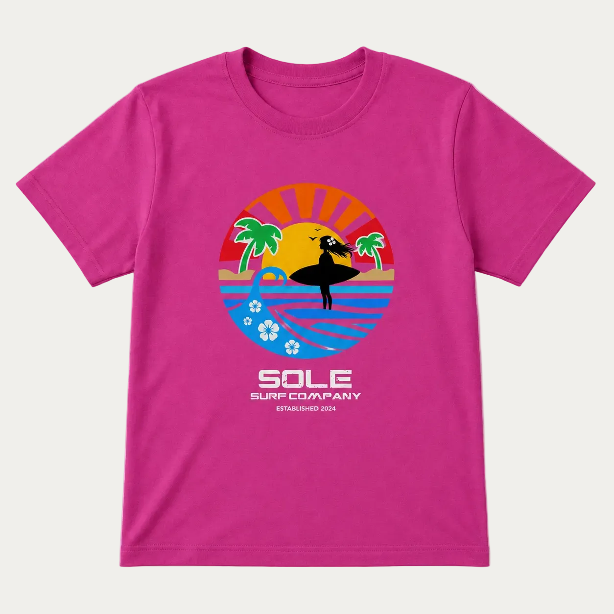 A bright pink short-sleeve t-shirt with a colorful retro-style surf graphic on the chest. The graphic features a surfer silhouette against a sunset and ocean, with the text 'SOLE SURF COMPANY ESTABLISHED 2024' printed below.