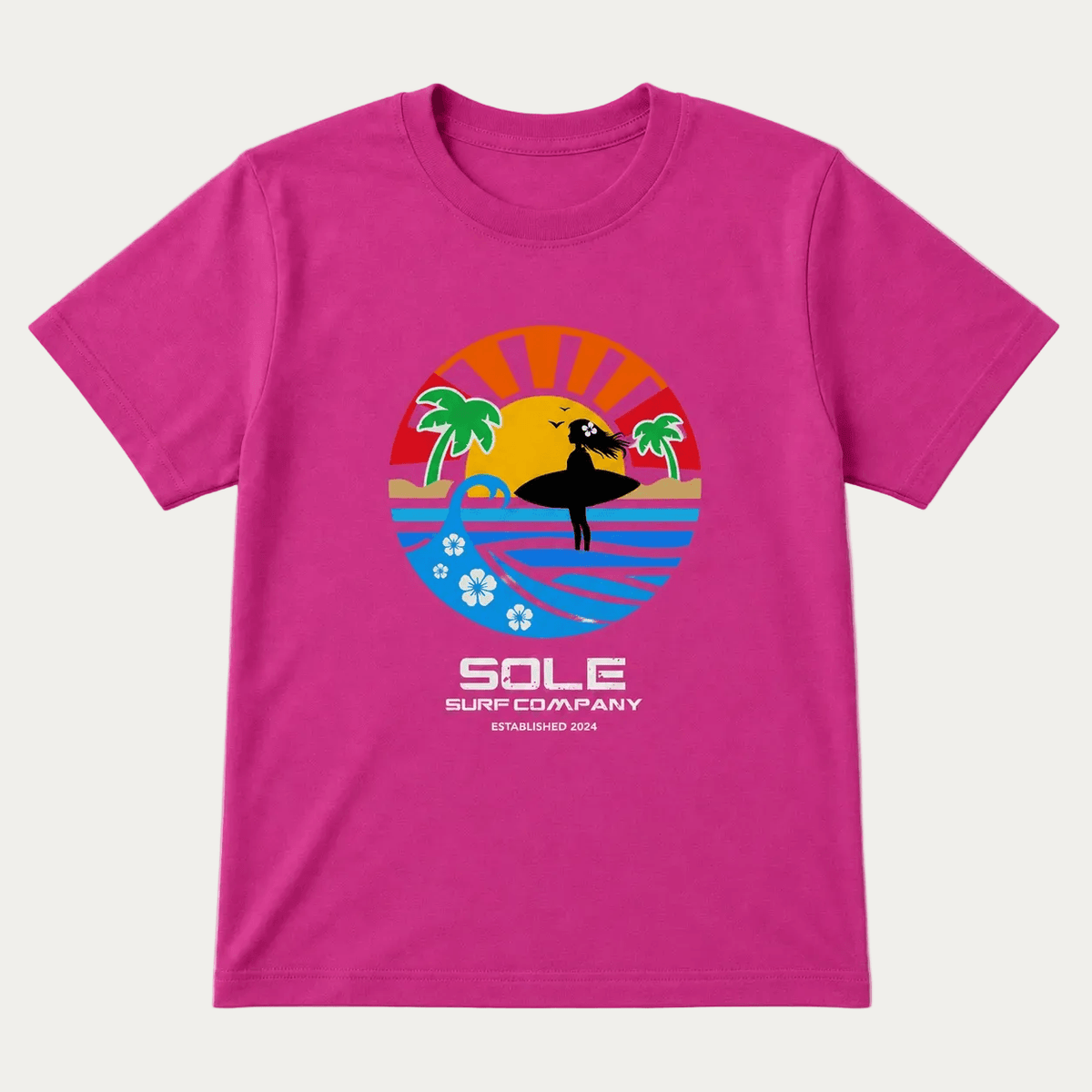 A bright pink short-sleeve t-shirt with a colorful retro-style surf graphic on the chest. The graphic features a surfer silhouette against a sunset and ocean, with the text 'SOLE SURF COMPANY ESTABLISHED 2024' printed below.
