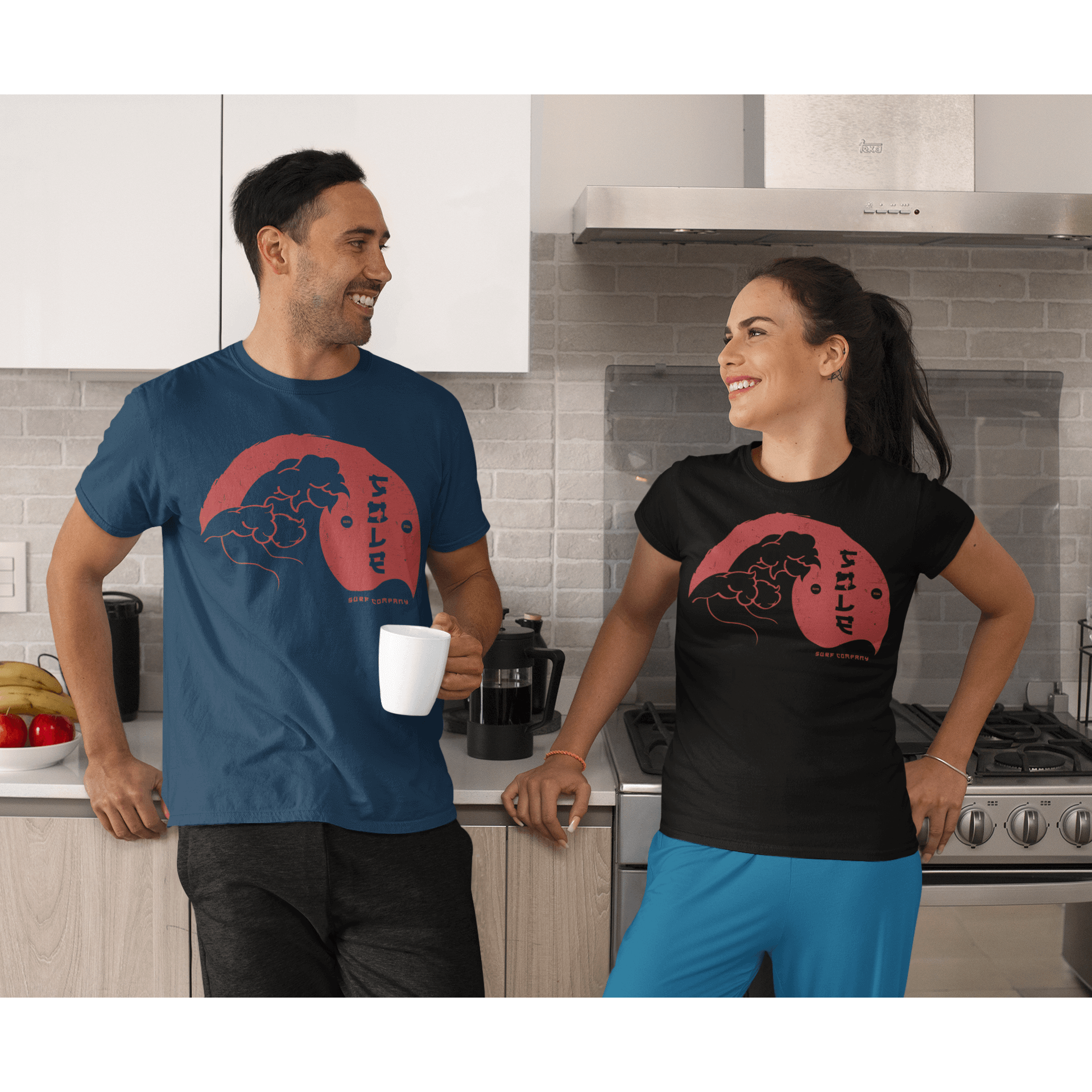 Two people wearing Japanese Wave design T-shirts in a modern kitchen, showcasing unique art and casual style.