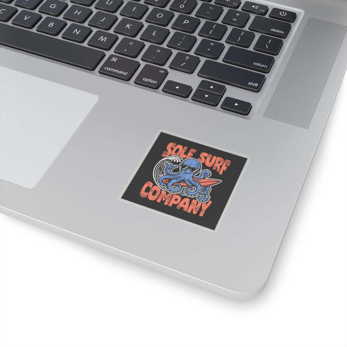 Surfing octopus sticker on a laptop showcasing vibrant colors and ocean-themed design from Sole Surf Company.