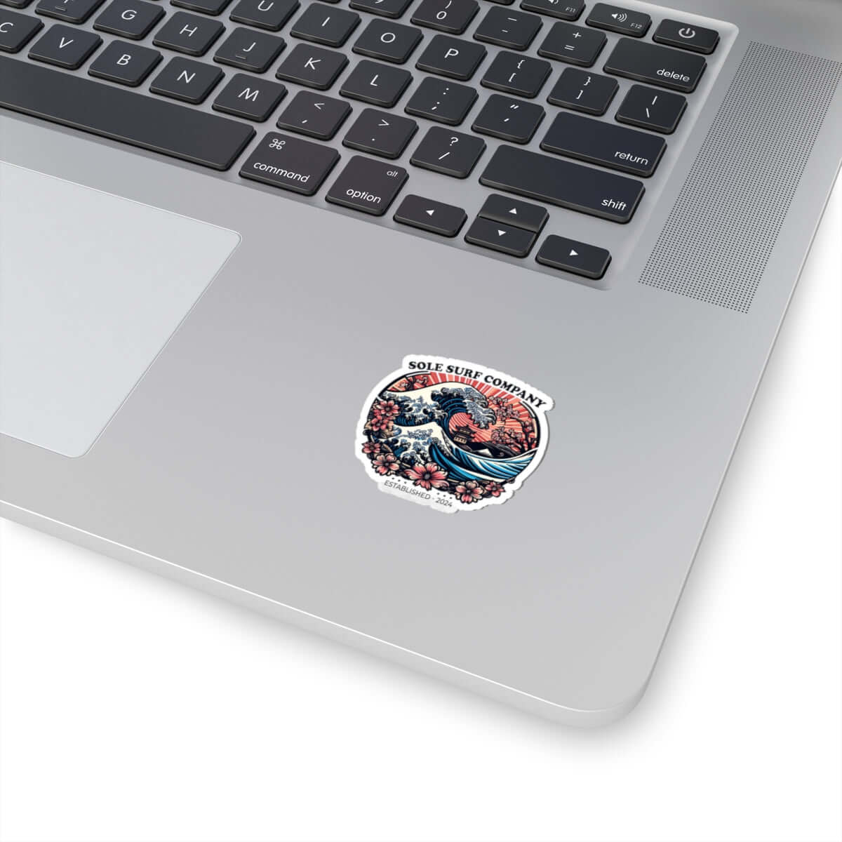 Vibrant Japanese sticker on laptop, showcasing artistic wave design and surf company logo, perfect for personalizing items.