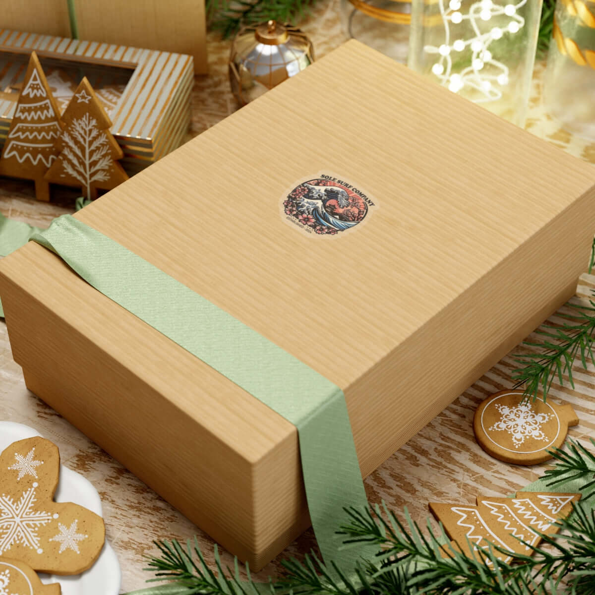 Elegant brown gift box tied with a green ribbon, decorated for the holidays, surrounded by festive decorations.