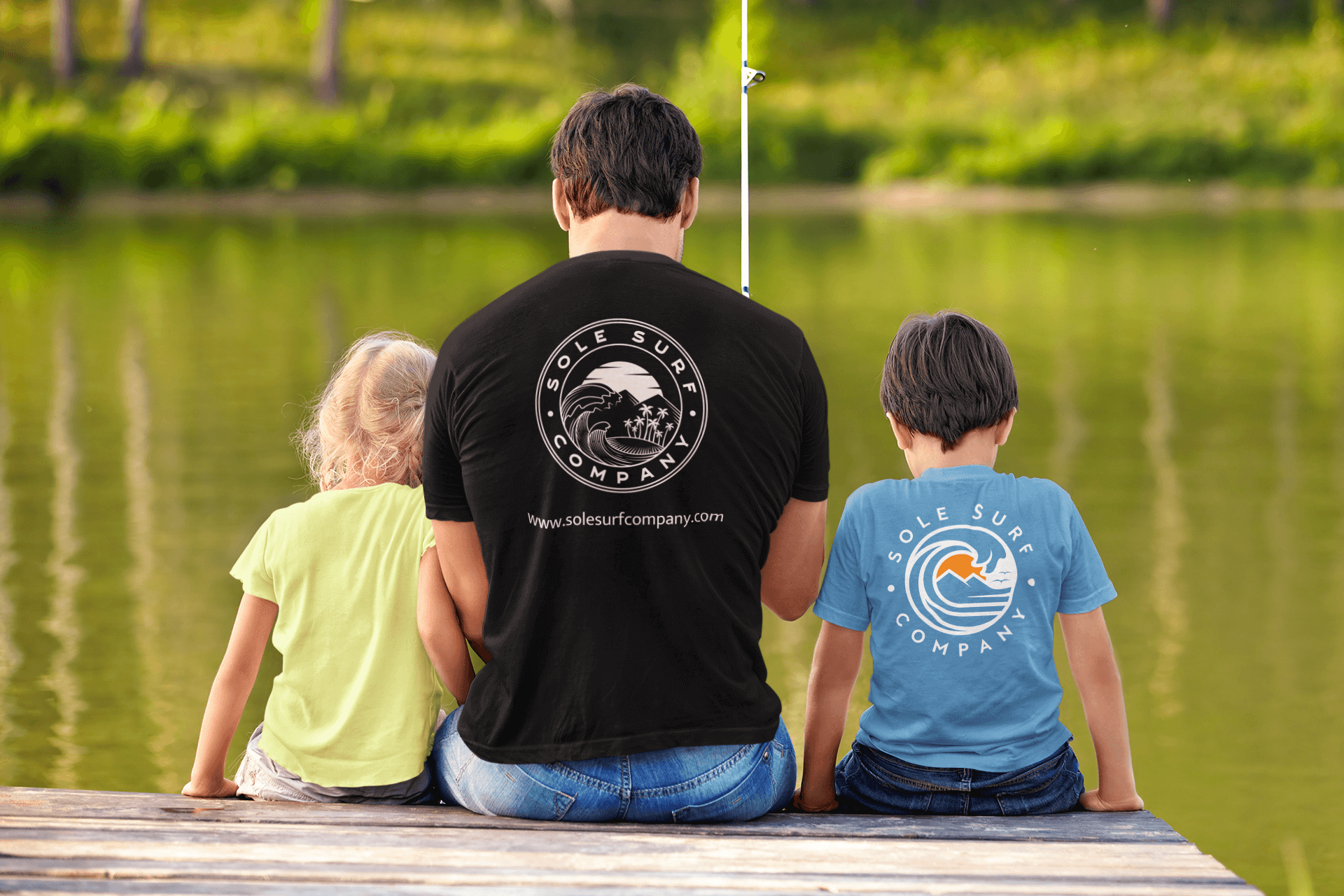 Family wearing Sole Surf Company tees while fishing by the water, capturing a playful day outdoors.